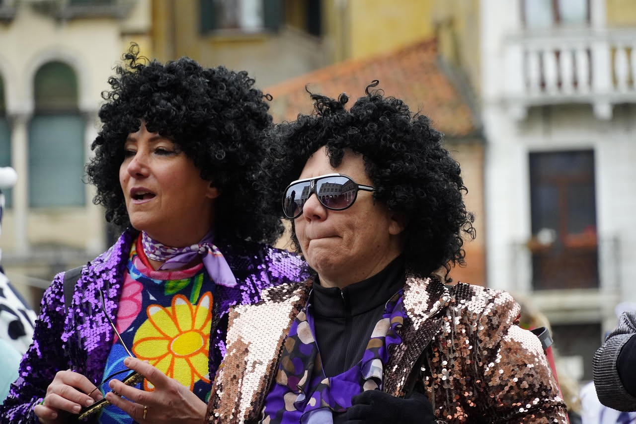 Donna con capelli castani e riflessi dorati che mostra il risultato di una colorazione professionale, con ricrescita ben coperta e colore uniforme
